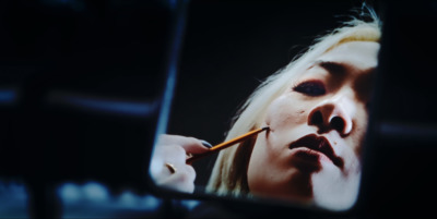 a woman is brushing her teeth in the mirror