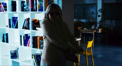 a woman standing in front of a book shelf