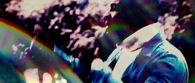 a man standing in front of a tree with a rainbow in the background