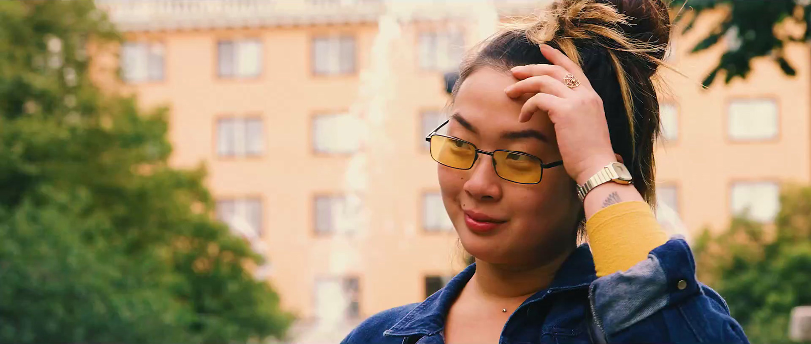 a woman wearing glasses and a denim jacket