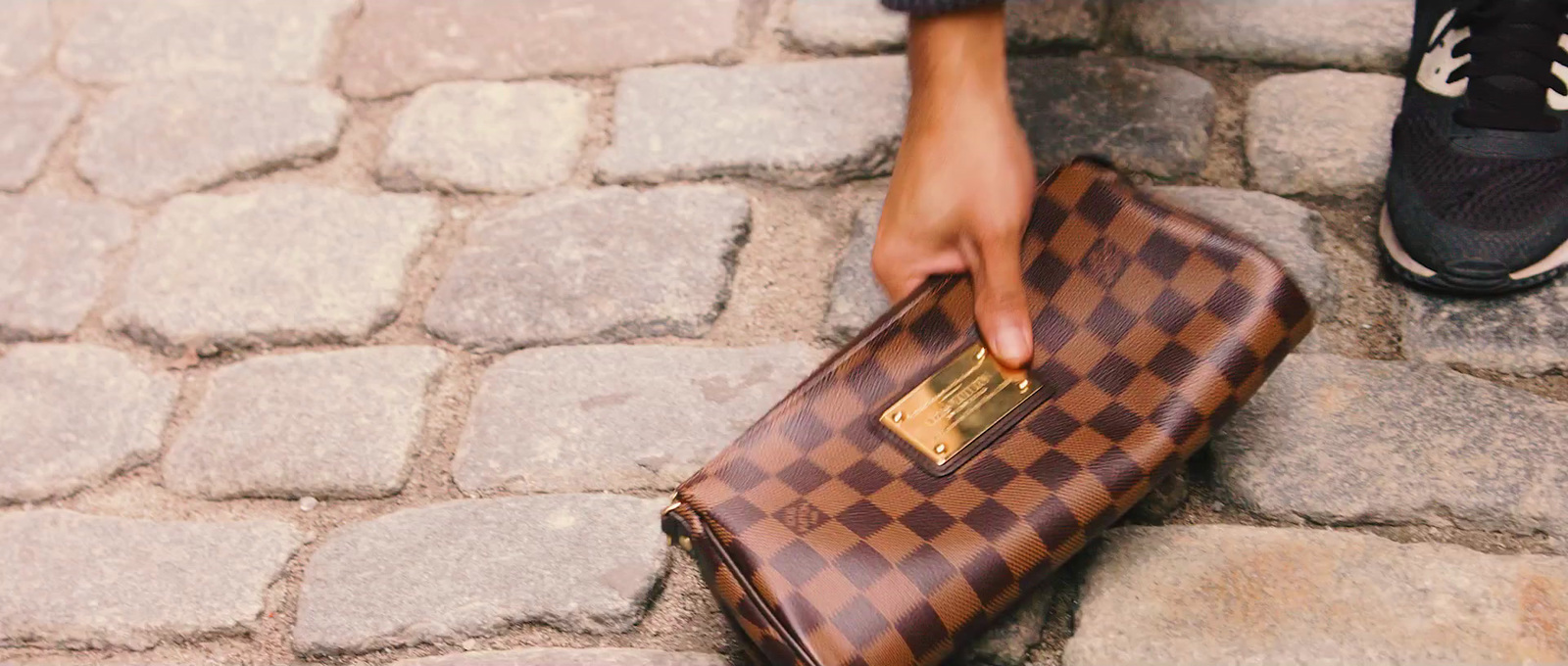 a person holding a brown and black purse