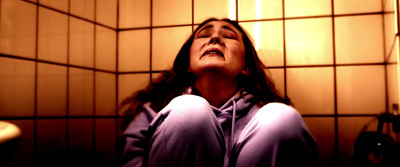 a woman sitting in a bathroom with her eyes closed