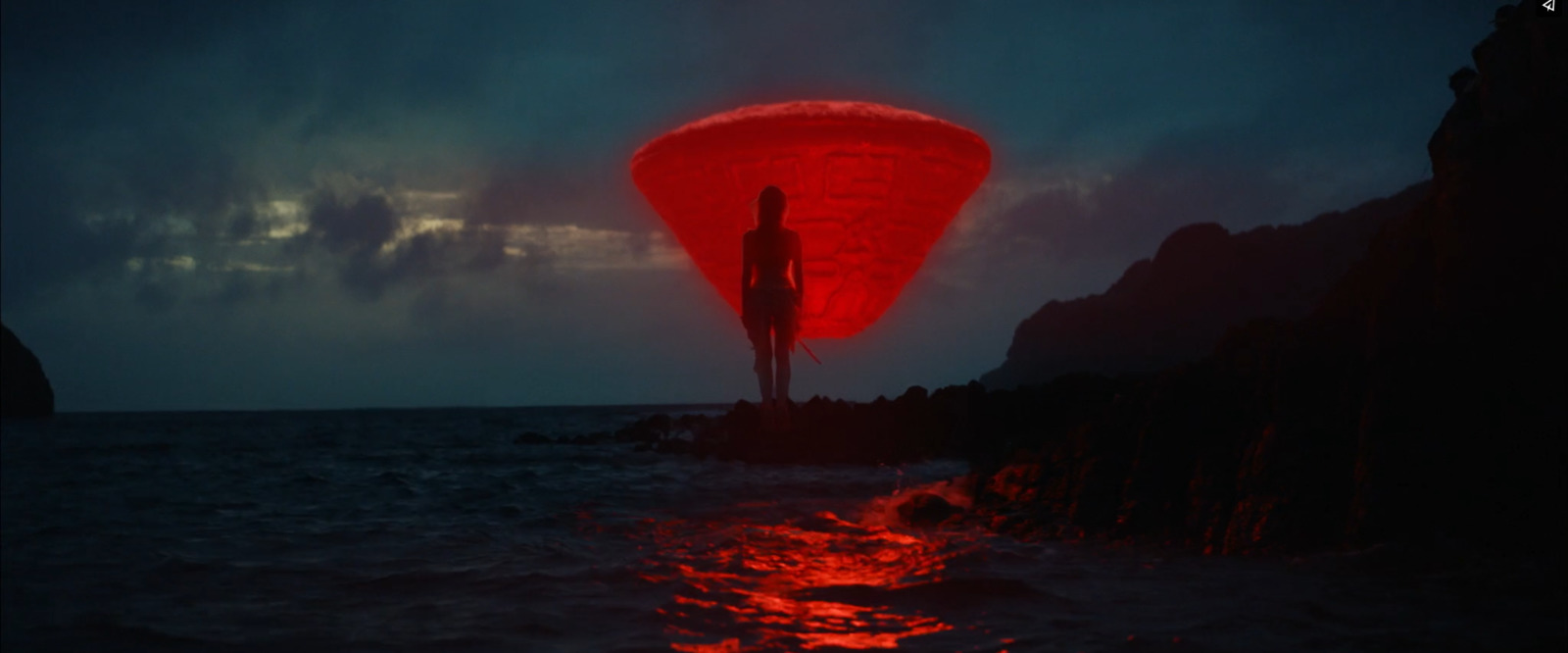 a person standing on a rock in the ocean at night