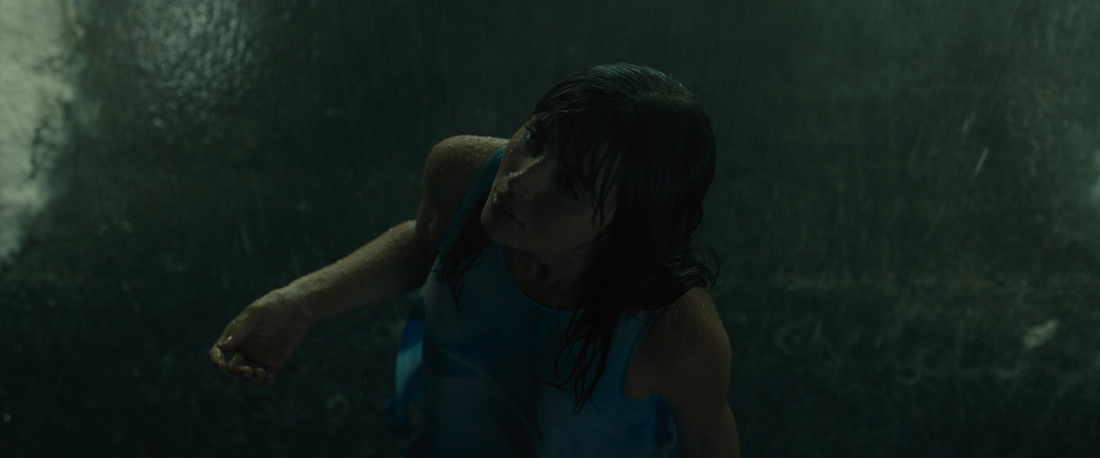 a woman standing in the rain with her hand on her face