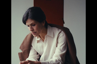 a woman sitting in a chair looking at a laptop