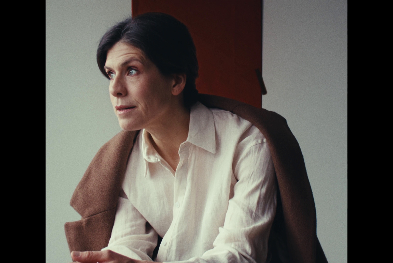 a woman in a white shirt and a brown scarf