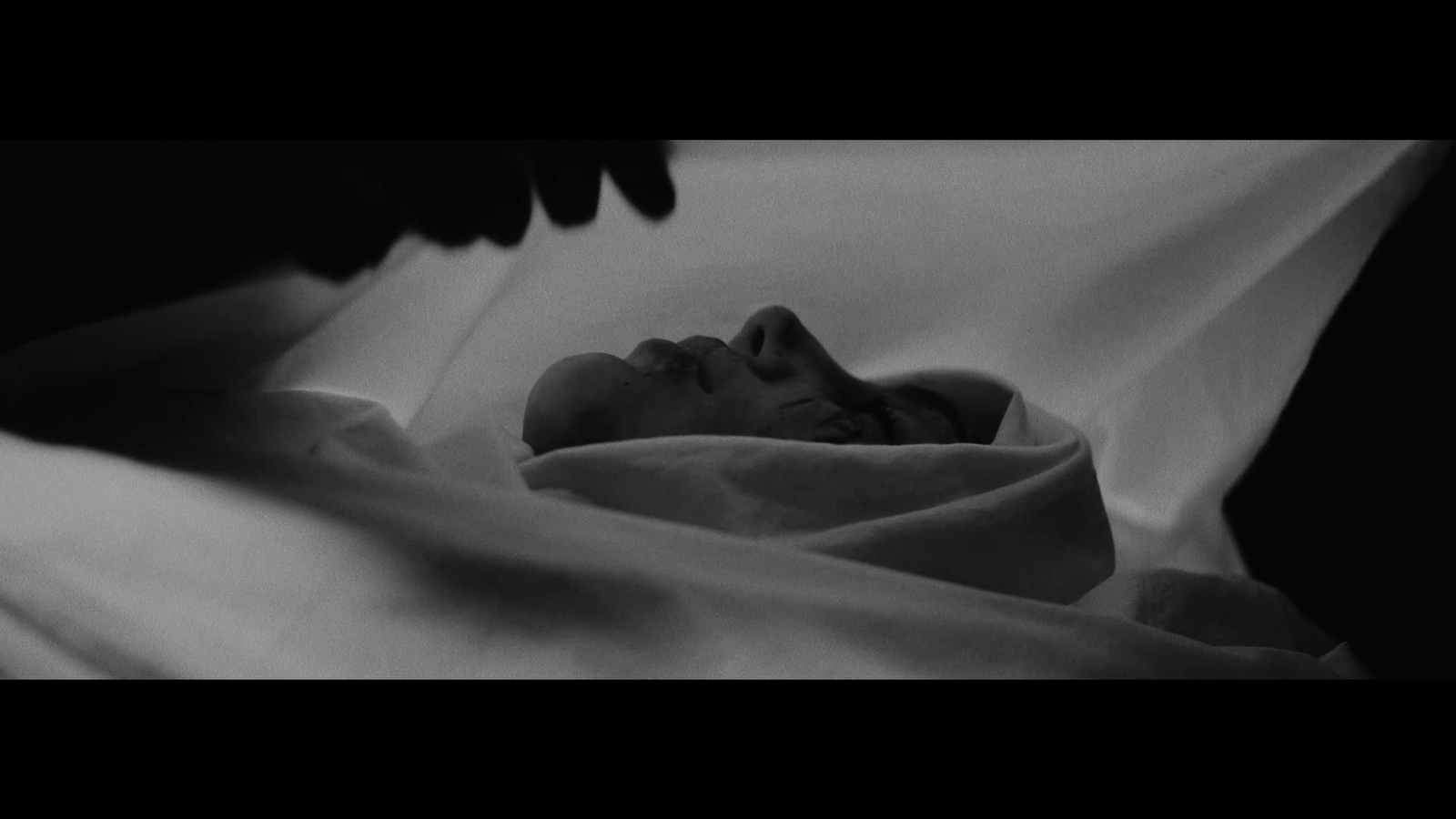 a black and white photo of a baby wrapped in a blanket