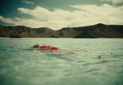 a woman floating on top of a body of water