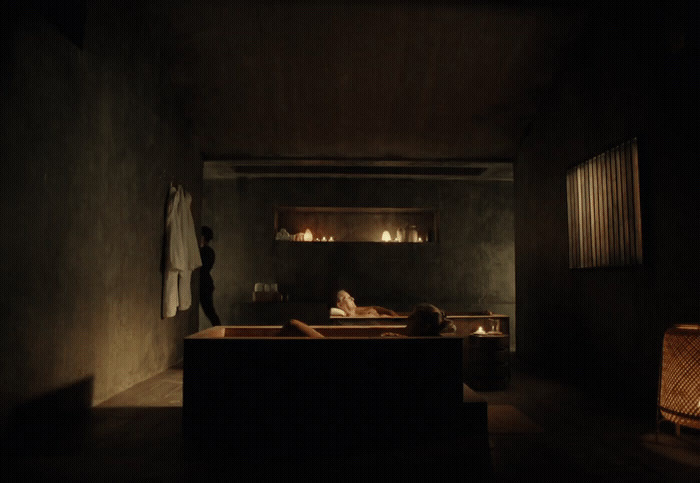 a woman laying in a bathtub in a dimly lit room