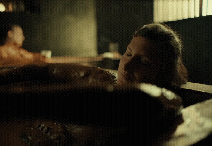 a woman laying in a bathtub with her eyes closed