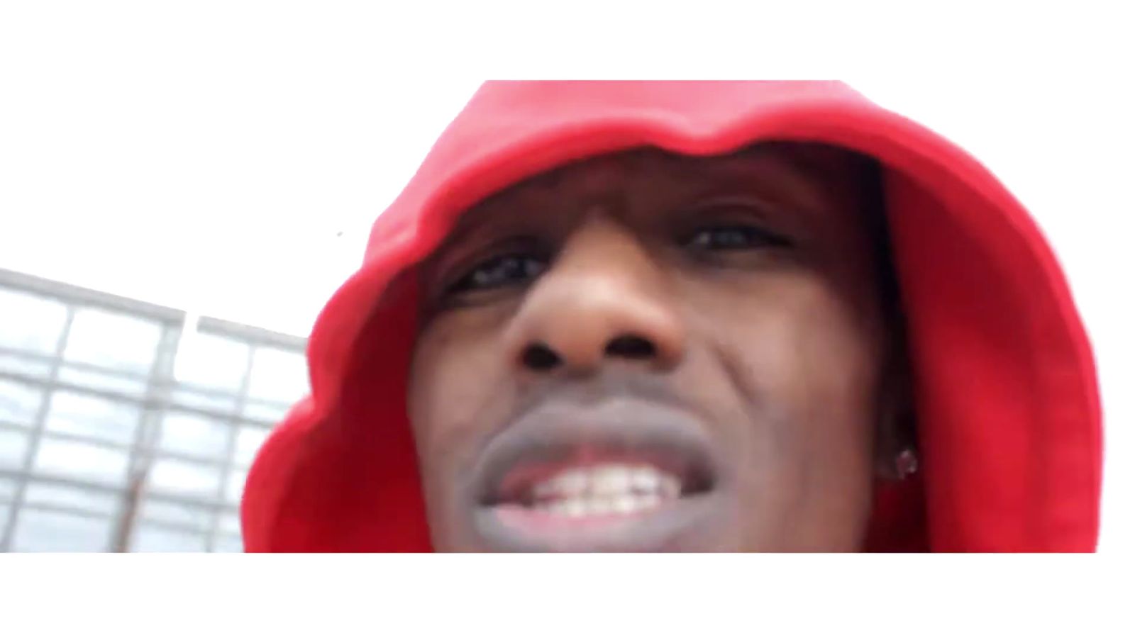 a man in a red hoodie is making a face