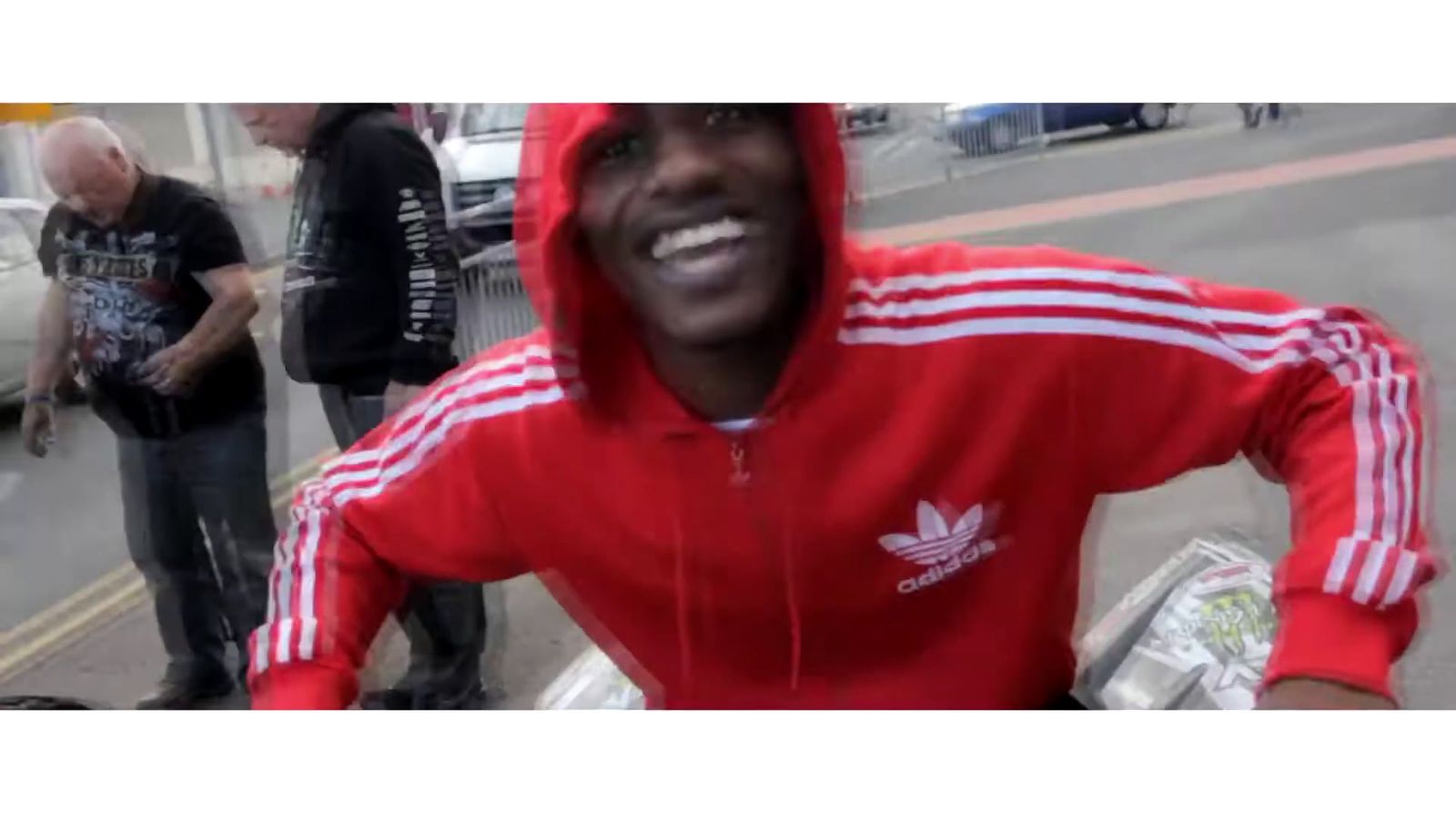 a man in a red hoodie is smiling