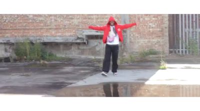 a woman in a red jacket is doing a trick on a skateboard