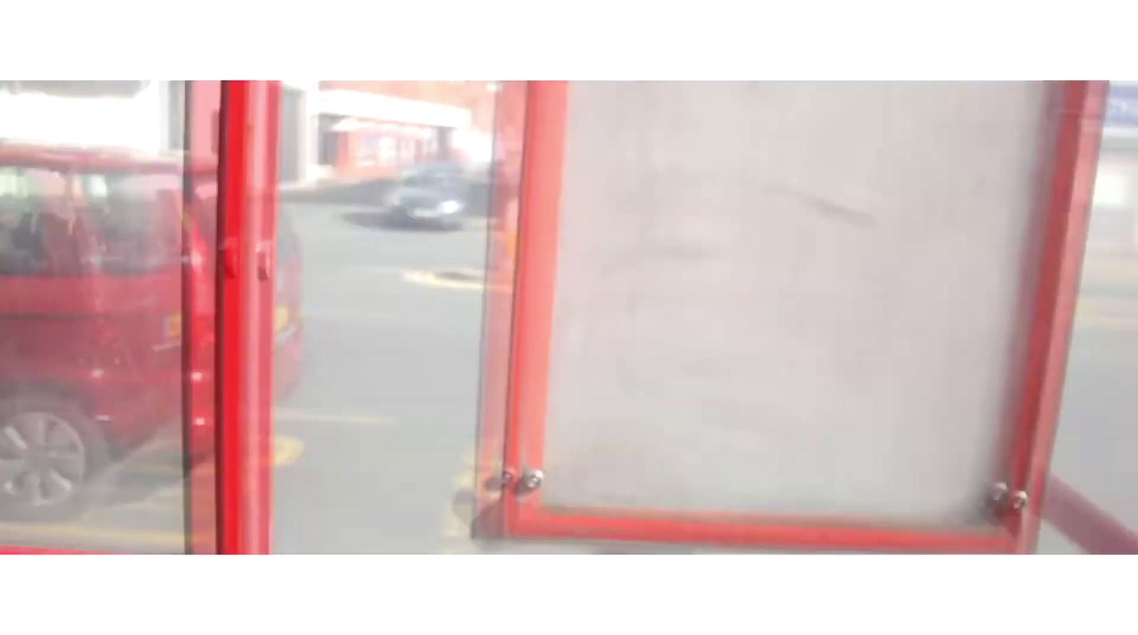 a red van is parked in front of a glass door