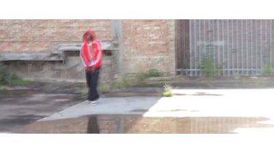 a person standing on a sidewalk in front of a building