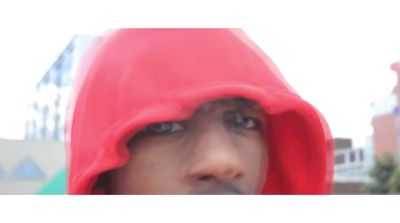 a man in a red hoodie looking at the camera