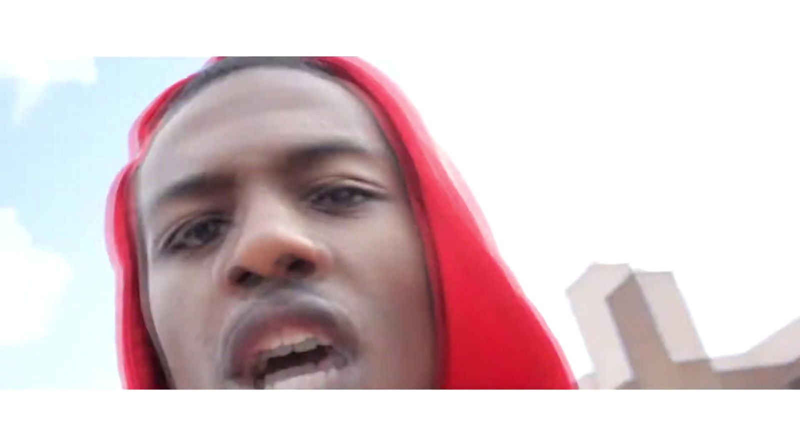 a man in a red hoodie making a face