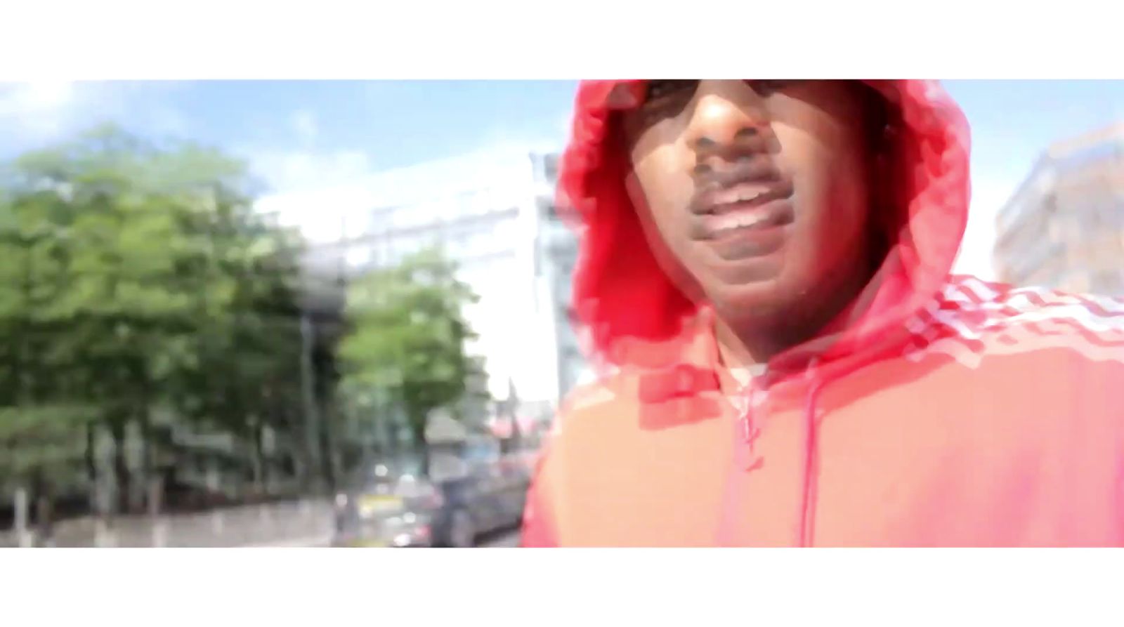 a man in a red hoodie is standing in the street