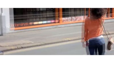 a woman walking down a street holding a purse