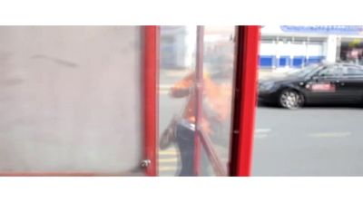 a car is parked in front of a bus stop