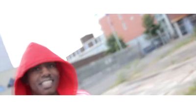 a man in a red hoodie is making a face