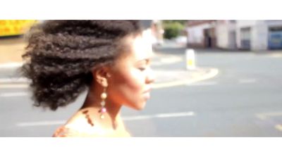 a woman walking down a street next to a traffic light