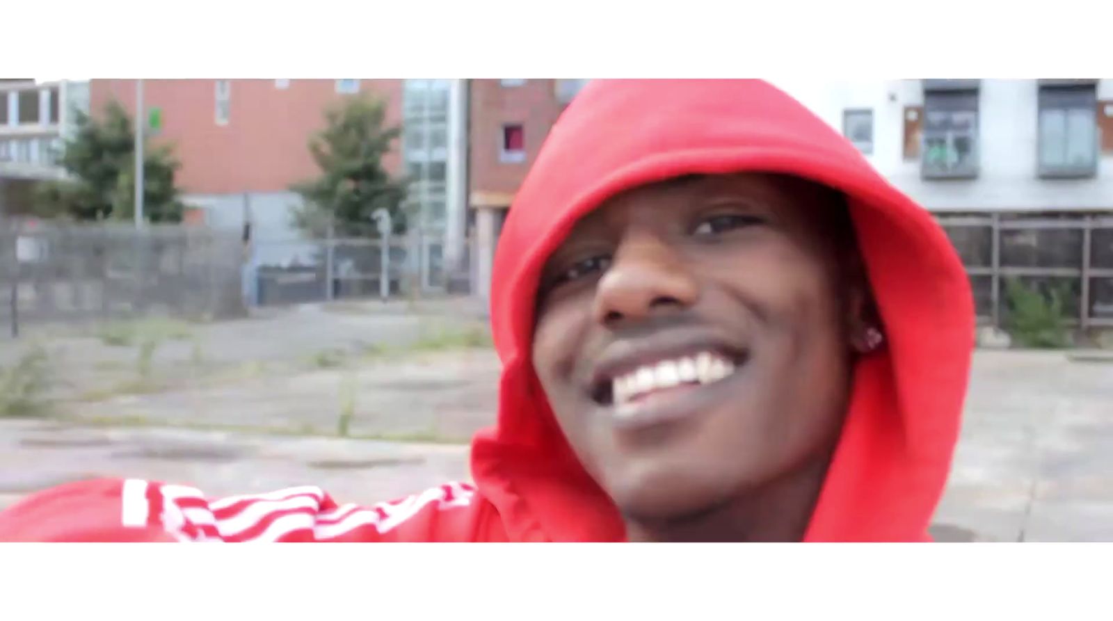 a man in a red hoodie is smiling