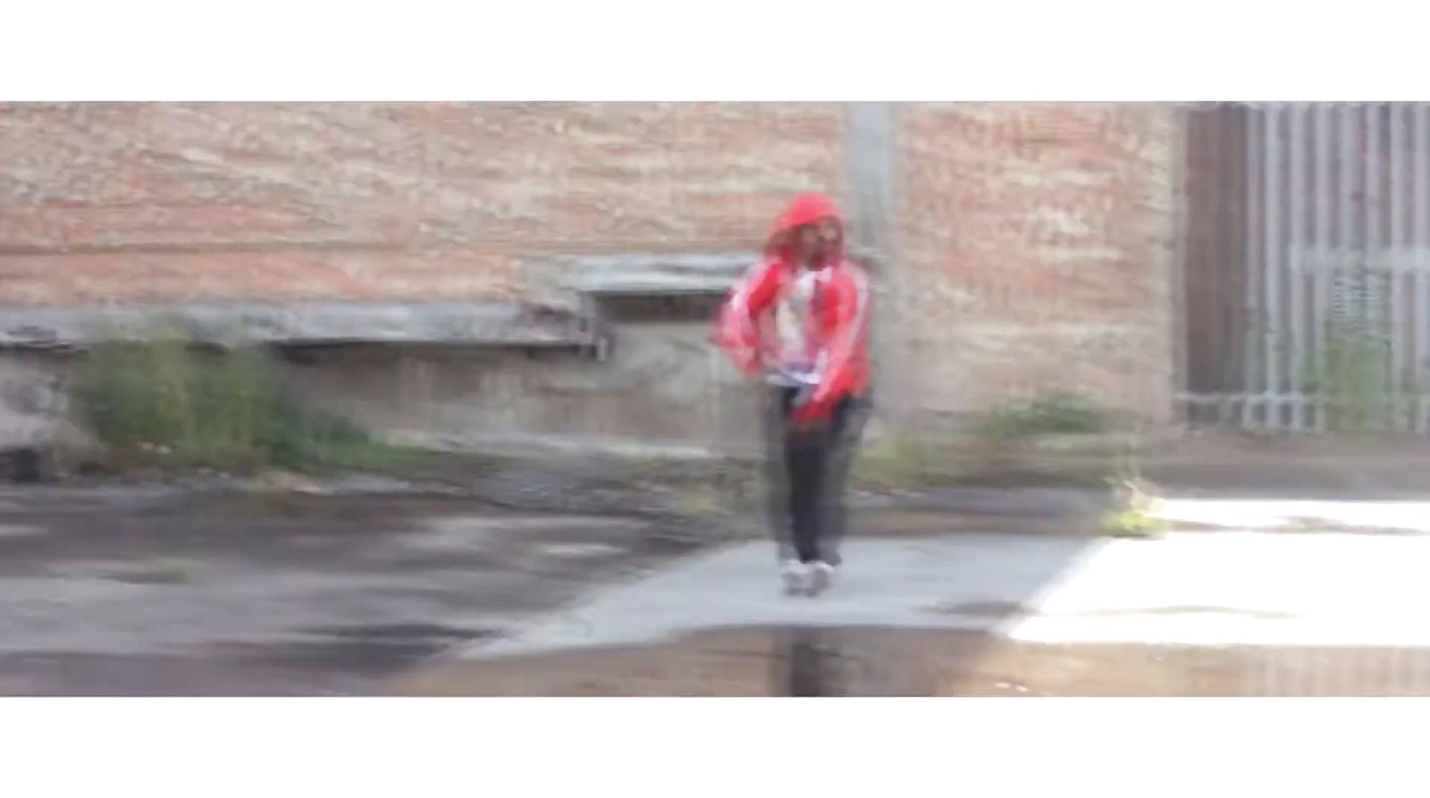 a person walking down a sidewalk in the rain