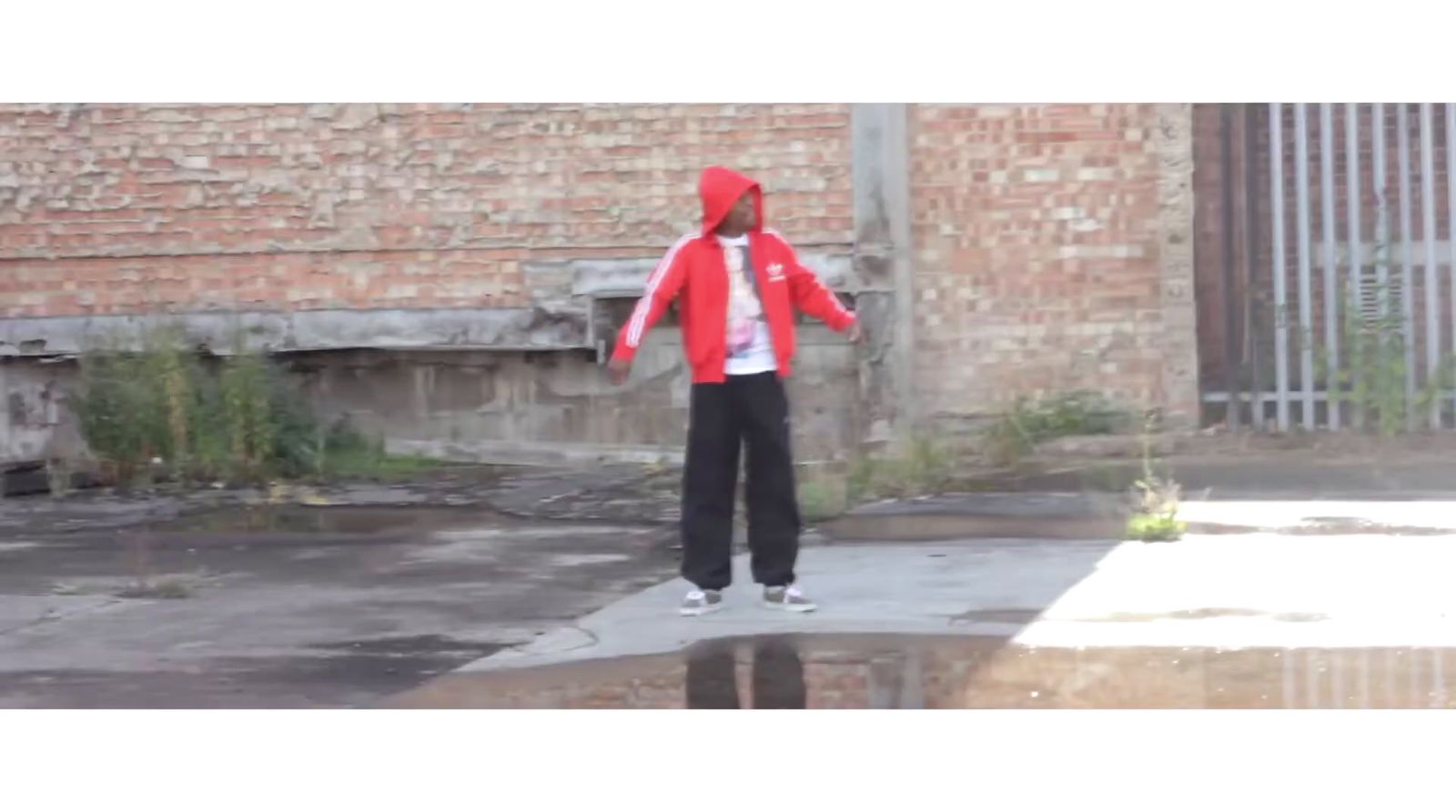 a man in a red jacket is standing on a sidewalk