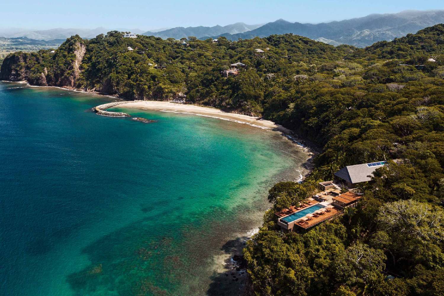 an aerial view of a tropical island with a swimming pool