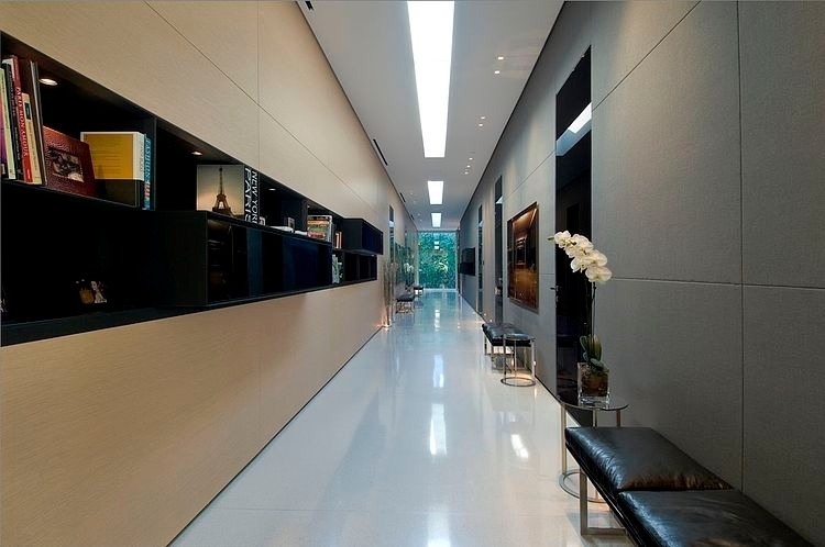 a long hallway with a bench and bookshelves