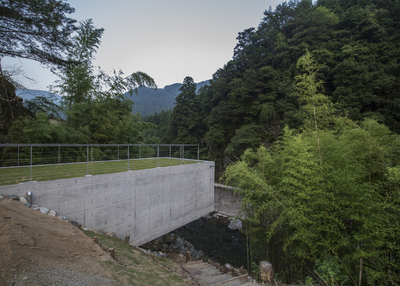 a concrete bridge over a river surrounded by trees