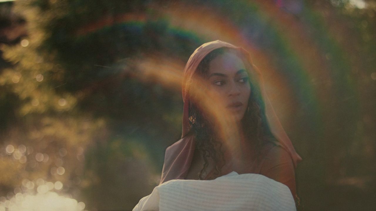 a woman standing in front of a rainbow