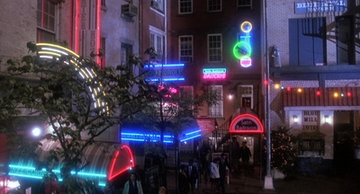 a group of people walking down a street at night