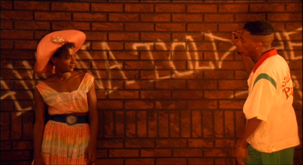 a man and a woman standing next to a brick wall