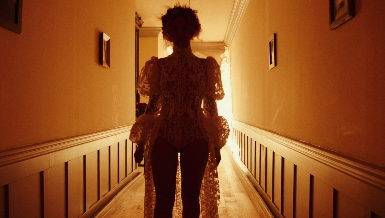 a woman is walking down a long hallway