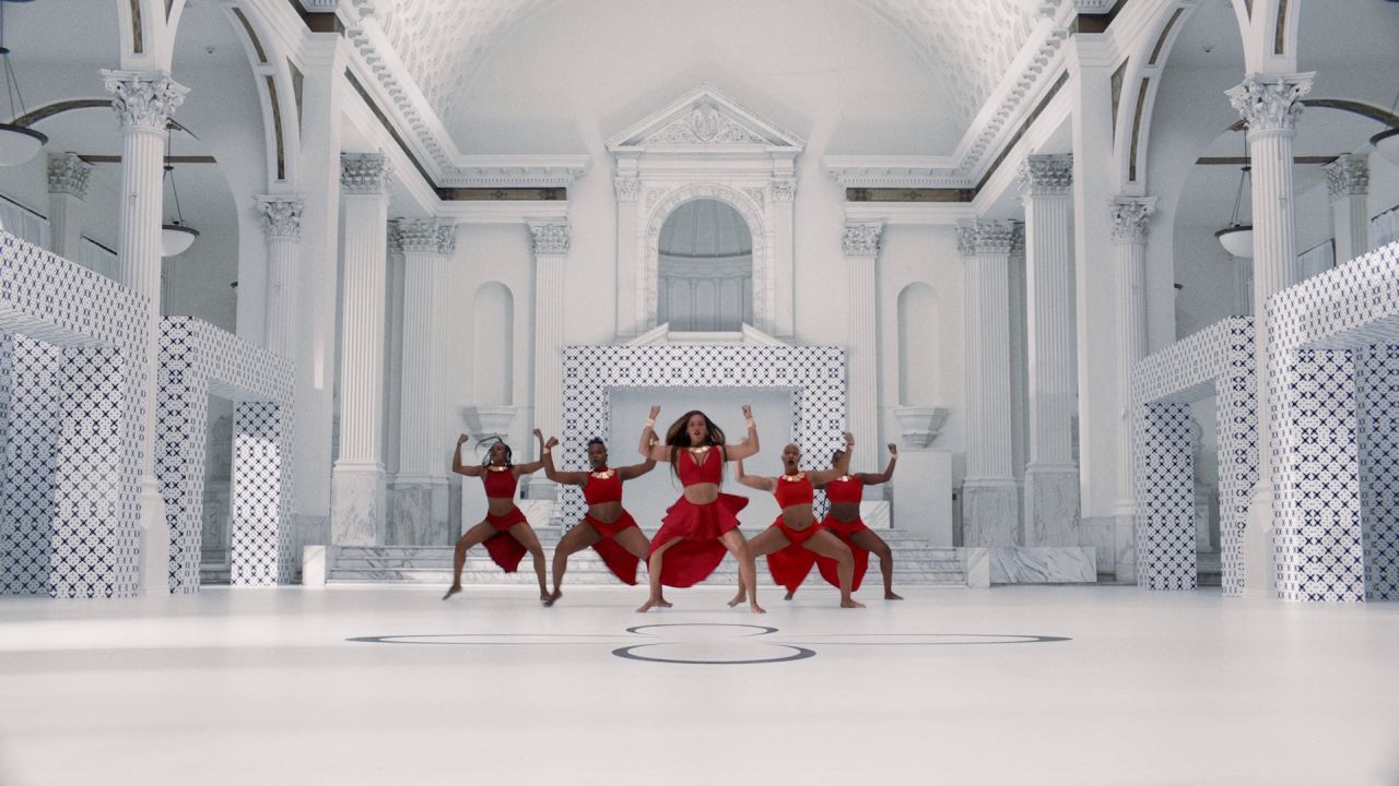 a group of women dancing on a white floor