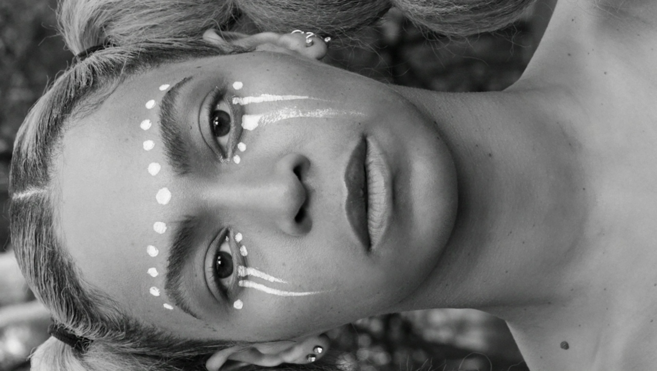 a young girl with white face paint on her face