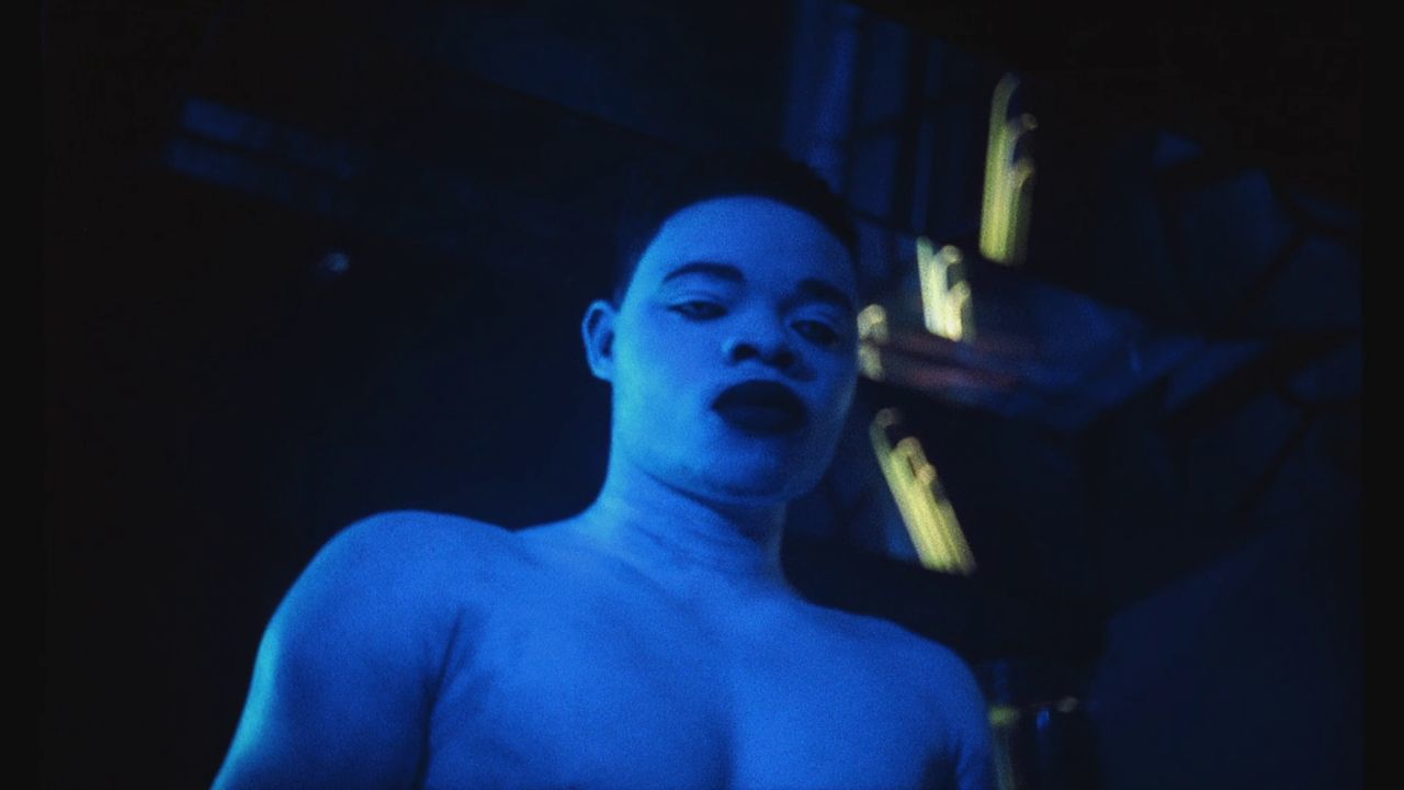 a shirtless man with blue paint on his face