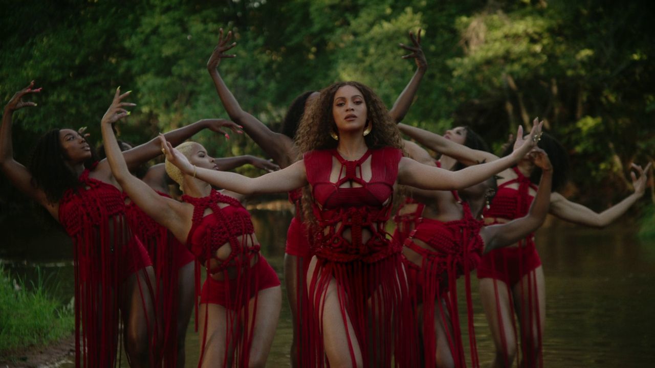 a group of women dressed in red dancing in the water