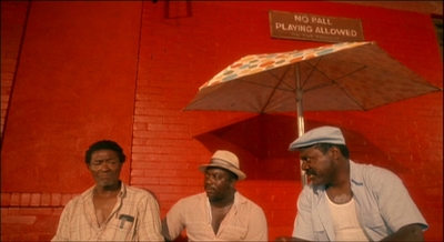 a group of men sitting next to each other under an umbrella