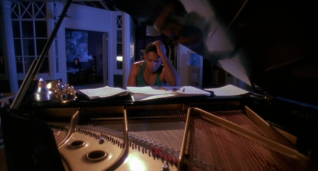 a woman is sitting at a piano and talking on the phone