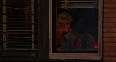 a woman looking out of a window at a man