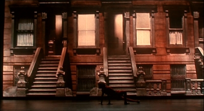 a man walking past a tall building with many windows