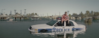 a woman standing on top of a police car in a flooded street