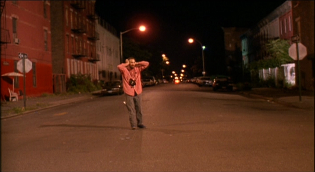 a man standing in the middle of a street at night