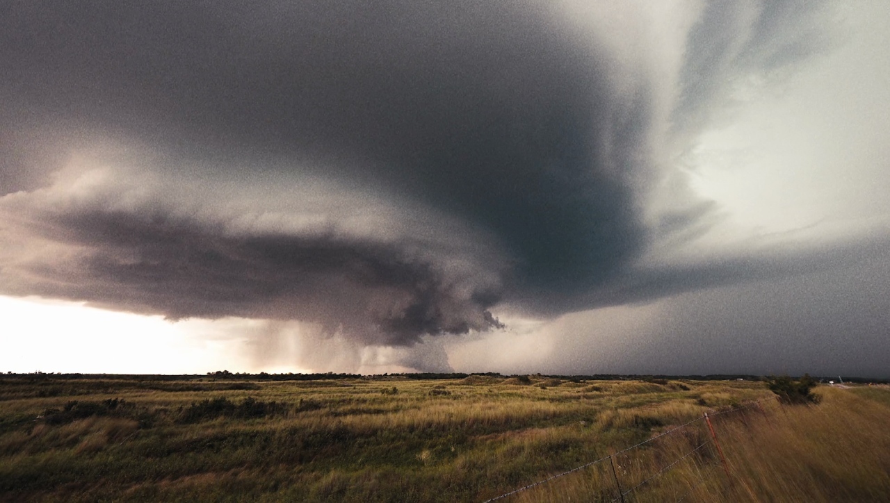 a large cloud is in the sky over a field