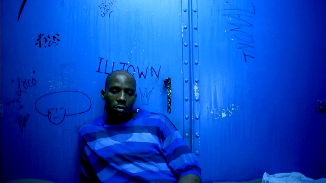 a man sitting in a blue room with graffiti on the walls