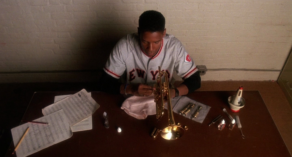 a man sitting at a table with a saxophone