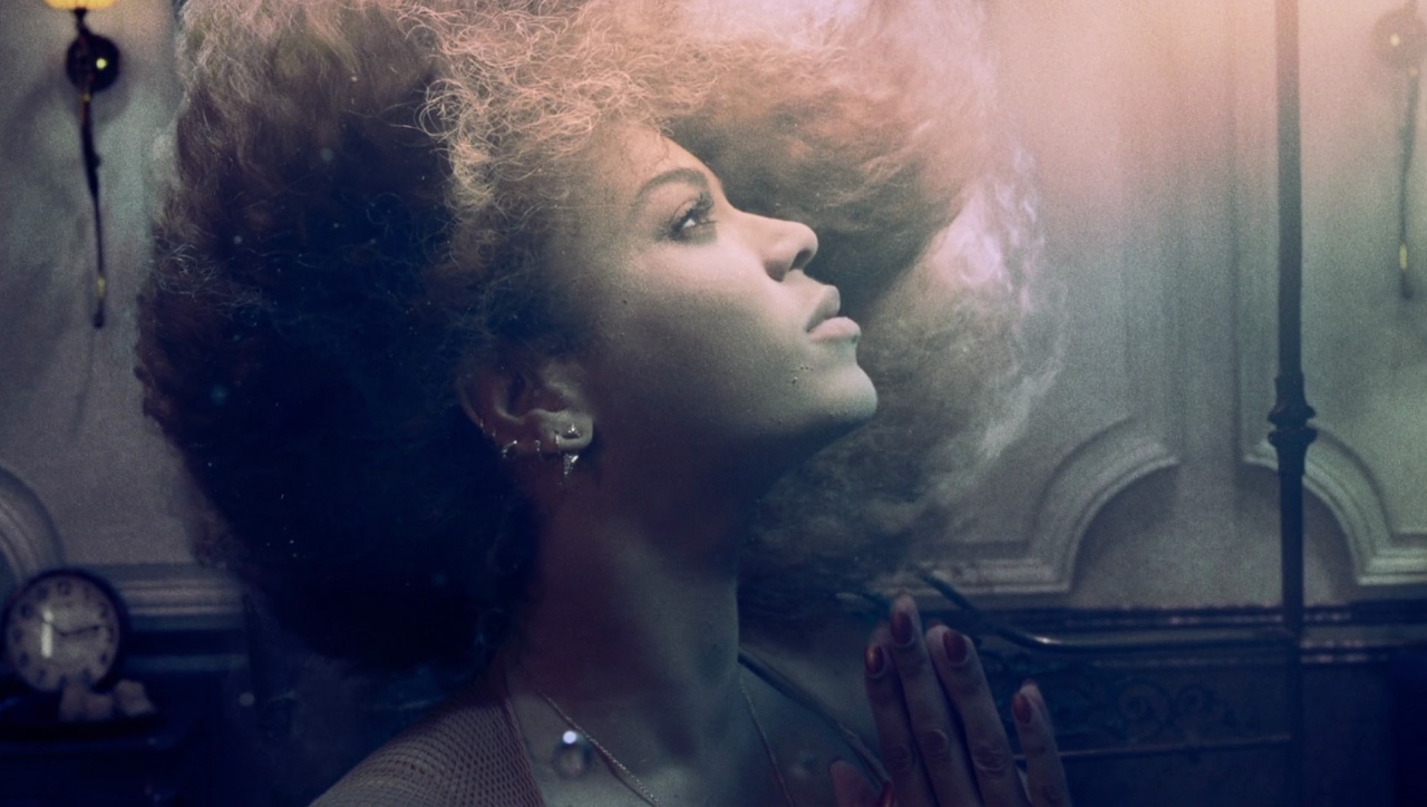 a woman with curly hair standing in front of a mirror